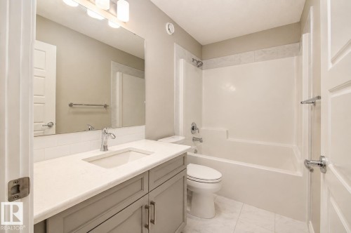 Bathroom featuring a white bathtub, vanity with a light gray cabinet, white countertop, and white subway tile backsplash - 7274 Morgan Road Nw, Edmonton, AB - Indoor Photo Showing Bathroom