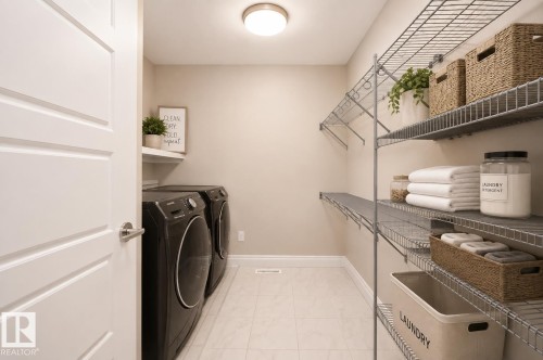 Laundry area featuring tile flooring, built-in shelving, and a permanent wall shelf - 7274 Morgan Road Nw, Edmonton, AB - Indoor Photo Showing Laundry Room