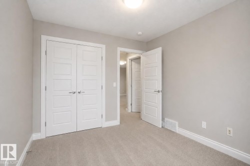 Neutral-toned walls with coordinated carpeting, white trim, and a flush-mount ceiling light fixture - 7274 Morgan Road Nw, Edmonton, AB - Indoor Photo Showing Other Room