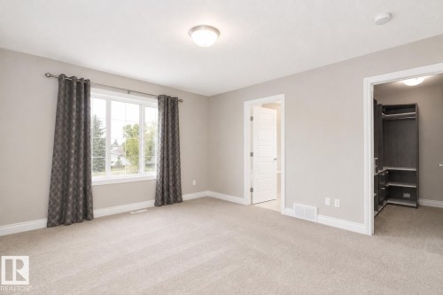 Spacious room with large windows, neutral carpeting, and a built-in closet system - 7274 Morgan Road Nw, Edmonton, AB - Indoor Photo Showing Other Room