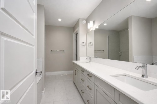 Dual vanity with integrated sinks, chrome fixtures, and an expansive mirror - 7274 Morgan Road Nw, Edmonton, AB - Indoor Photo Showing Bathroom