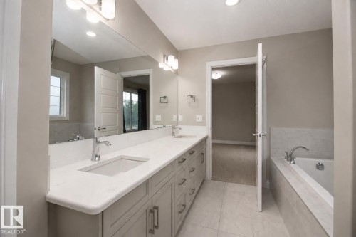 Dual vanity with undermount sinks, stone countertops, and chrome fixtures - 7274 Morgan Road Nw, Edmonton, AB - Indoor Photo Showing Bathroom