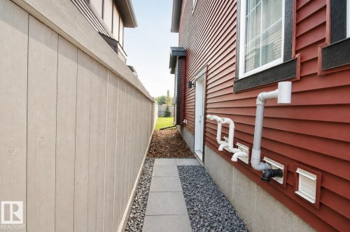 Red horizontal siding with white trim accents and dark window casings - 7274 Morgan Road Nw, Edmonton, AB - Outdoor With Exterior