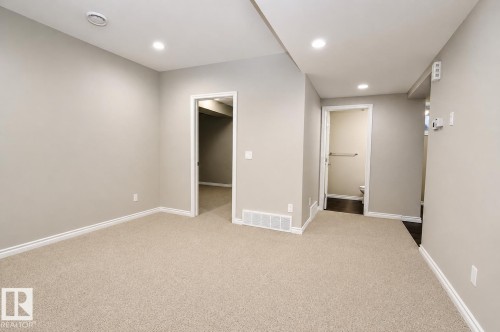 Recessed ceiling lighting, light-toned wall paint, neutral carpeting, white trim, and white doors - 7274 Morgan Road Nw, Edmonton, AB - Indoor Photo Showing Other Room