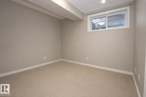 Recessed lighting, neutral wall paint, carpeted flooring, and a large window with white trim - 7274 Morgan Road Nw, Edmonton, AB - Indoor Photo Showing Other Room