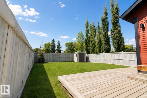 Expansive backyard featuring a wood-finish deck, level lawn, privacy fencing, and a storage shed - 7274 Morgan Road Nw, Edmonton, AB - Outdoor