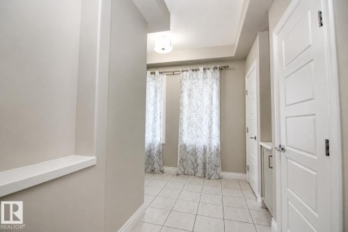 Recessed ceiling details, white panel doors, built-in shelf, tiled flooring, and a flush-mount light fixture - 7274 Morgan Road Nw, Edmonton, AB - Indoor Photo Showing Other Room