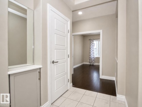 Entryway featuring tile flooring, built-in cabinetry with a white countertop and mirror, and a white paneled door - 7274 Morgan Road Nw, Edmonton, AB - Indoor Photo Showing Other Room