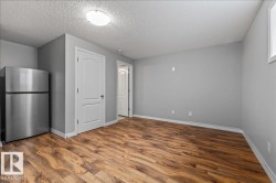 Spacious room featuring wood-finish flooring, light gray walls, and white trim - 
