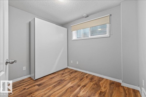 Room featuring a built-in white wall bed, wood-finish flooring, and a window with blinds - 1086 Grantham Drive Nw, Edmonton, AB - Indoor Photo Showing Other Room