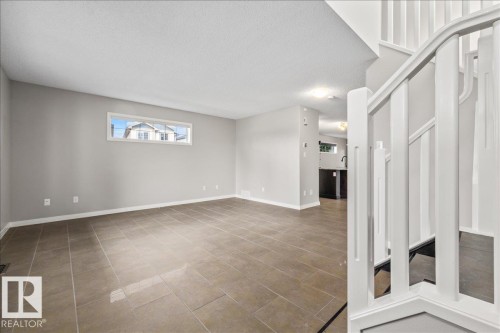 Open-concept living area with neutral gray walls and large format tile flooring - 1086 Grantham Drive Nw, Edmonton, AB - Indoor Photo Showing Other Room