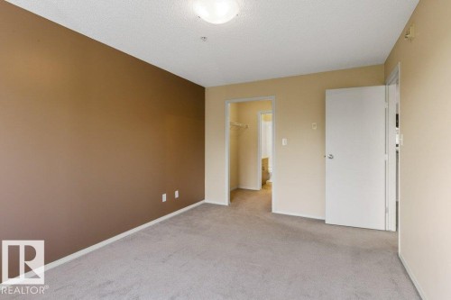 Wall-to-wall carpeting and neutral wall tones - #307 1188 Hyndman Rd Nw, Edmonton, AB - Indoor Photo Showing Other Room