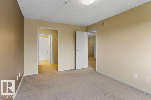 Neutral tone wall paint, light-colored carpeting, white trim, and a ceiling-mounted light fixture - #307 1188 Hyndman Rd Nw, Edmonton, AB - Indoor Photo Showing Other Room