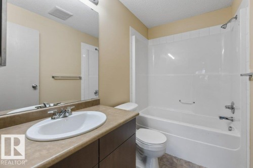 Vanity with integrated sink, chrome faucet, and substantial mirror - #307 1188 Hyndman Rd Nw, Edmonton, AB - Indoor Photo Showing Bathroom