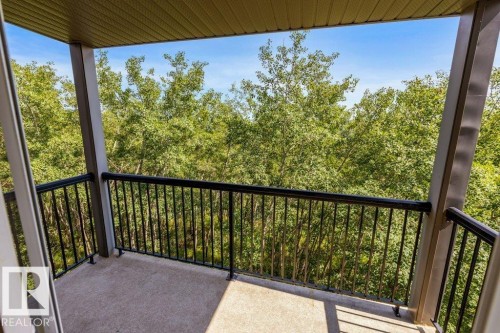 Covered balcony featuring concrete flooring and black metal railings - #307 1188 Hyndman Rd Nw, Edmonton, AB - Outdoor With Balcony With Exterior