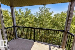 Covered balcony featuring concrete flooring and black metal railings - 