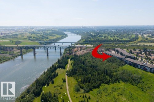 Riverside setting with multiple bridges, adjacent to a wooded area and multi-story residential buildings - #307 1188 Hyndman Rd Nw, Edmonton, AB - Outdoor With View