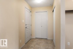 Tile flooring, flush mount lighting, white paneled doors, and a built-in storage niche - 