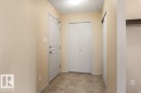 Tile flooring, flush mount lighting, white paneled doors, and a built-in storage niche - #307 1188 Hyndman Rd Nw, Edmonton, AB  - Indoor Photo Showing Other Room 