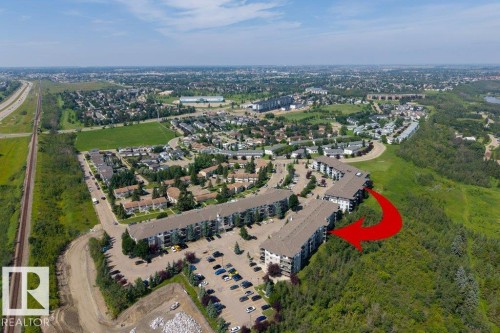 Multi-story residential buildings with surface parking areas and mature landscaping - #307 1188 Hyndman Rd Nw, Edmonton, AB - Outdoor With View