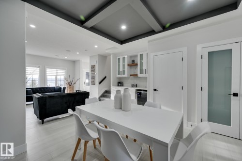 Open-concept living space featuring light wood-finish flooring, recessed lighting, and a tray ceiling with dark accents - 51 Clichy Close, St. Albert, AB - Indoor