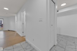 Recessed ceiling lighting, white walls, wood-finish flooring, and white tile flooring - 