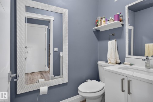 Bathroom vanity featuring a single basin, integrated countertop, and modern cabinetry with brushed nickel hardware - 1344 Lakewood Road West Nw, Edmonton, AB - Indoor Photo Showing Bathroom