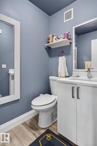 Contemporary bathroom with a white vanity featuring modern hardware, a white countertop, and an undermount sink - 1344 Lakewood Road West Nw, Edmonton, AB - Indoor Photo Showing Bathroom