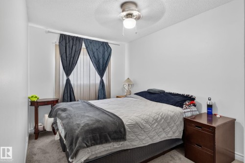 Bedroom featuring a ceiling fan, window with vertical blinds, and neutral wall paint - 1344 Lakewood Road West Nw, Edmonton, AB - Indoor Photo Showing Bedroom
