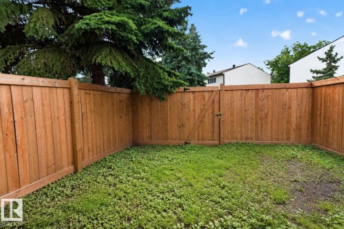 Fenced backyard featuring a wood fence, wooden gate, and a grass area - 1344 Lakewood Road West Nw, Edmonton, AB - Outdoor