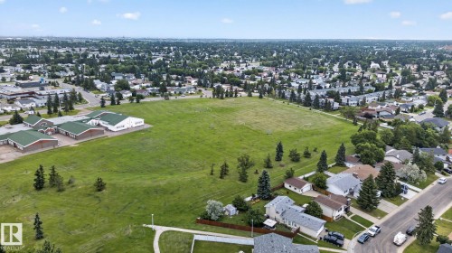 Expansive green space bordered by residential properties and a commercial structure - 1344 Lakewood Road West Nw, Edmonton, AB - Outdoor With View