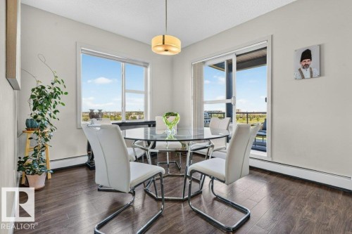 Wood-finish flooring, white walls, and a contemporary ceiling light fixture - #423 320 Ambleside Li Sw, Edmonton, AB - Indoor Photo Showing Dining Room