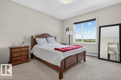 Carpeted flooring, neutral wall tones, and a window with a roller shade - #423 320 Ambleside Li Sw, Edmonton, AB - Indoor Photo Showing Bedroom
