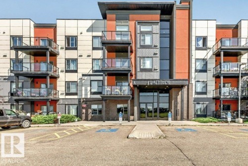 Contemporary multi-story building with a brick and panel facade, featuring multiple balconies with glass railings - #423 320 Ambleside Li Sw, Edmonton, AB - Outdoor With Balcony With Facade