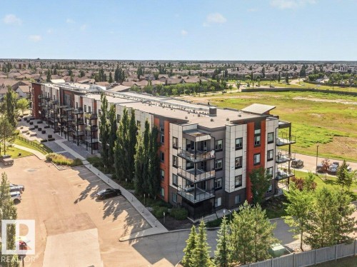 Modern multi-story building featuring multiple balconies with glass railings - #423 320 Ambleside Li Sw, Edmonton, AB - Outdoor With Balcony With View