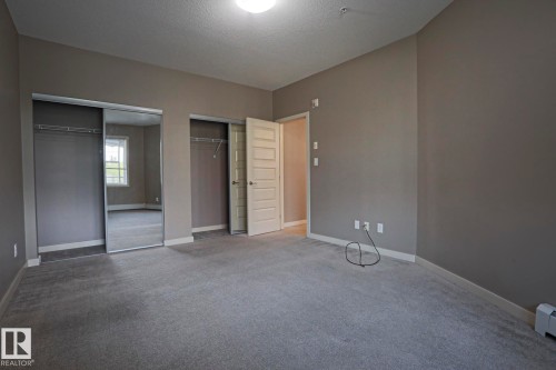 Wall-to-wall carpeting and neutral wall tones - #209 304 Ambleside Link Li Sw Sw, Edmonton, AB - Indoor Photo Showing Other Room