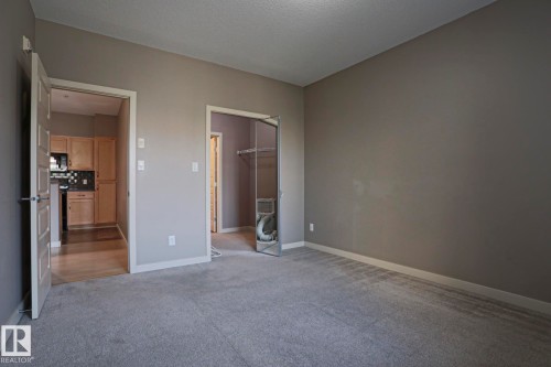 Plush gray carpeting and neutral wall paint - #209 304 Ambleside Link Li Sw Sw, Edmonton, AB - Indoor Photo Showing Other Room