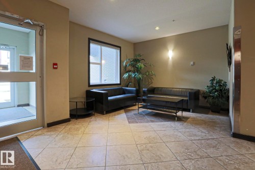 Recessed lighting, wall sconce, large window, tile flooring, glass-paneled door - #209 304 Ambleside Link Li Sw Sw, Edmonton, AB - Indoor Photo Showing Other Room