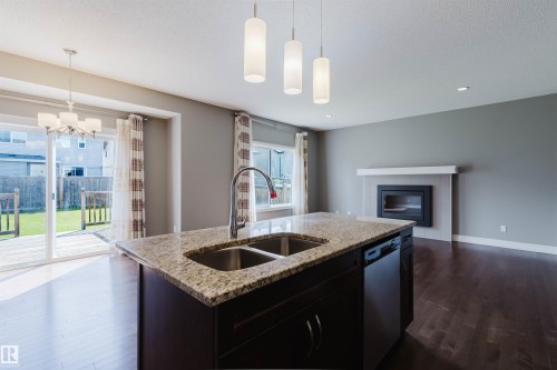 Kitchen island featuring a double-basin sink, gooseneck faucet, and integrated dishwasher - 15839 10 Avenue Sw, Edmonton, AB - Indoor Photo Showing Kitchen With Double Sink With Upgraded Kitchen