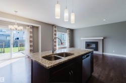 Kitchen island featuring a double-basin sink, gooseneck faucet, and integrated dishwasher - 