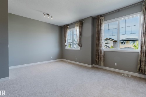 Carpeted flooring with white trim and a neutral color palette - 15839 10 Avenue Sw, Edmonton, AB - Indoor Photo Showing Other Room
