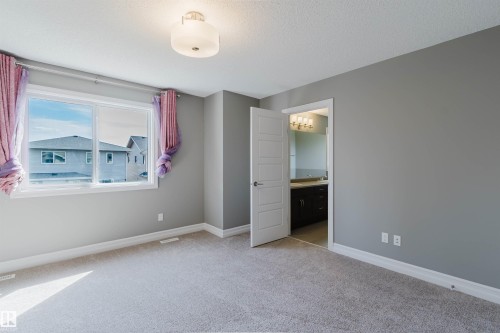 Neutral gray wall paint, plush carpeting, a multi-pane window, and a flush-mount ceiling light fixture - 15839 10 Avenue Sw, Edmonton, AB - Indoor