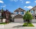Two-story residence featuring light-colored siding, a prominent two-car garage, and stone facade accents - 15839 10 Avenue Sw, Edmonton, AB  - Outdoor With Facade 