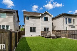 Expansive green lawn, elevated wood deck, sliding glass door access, and wood privacy fencing - 