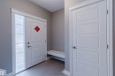 Entryway featuring a paneled door with frosted sidelight, white trim, and light gray wall paint - 15839 10 Avenue Sw, Edmonton, AB  - Indoor Photo Showing Other Room 
