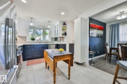 Kitchen with paneled cabinetry, stainless steel appliances, recessed lighting, and a bay window - 