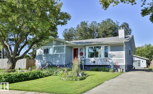 Stucco exterior with a pitched roof, front garden landscaping, a concrete driveway, and a detached garage - 8932 187 Street Nw, Edmonton, AB - Outdoor