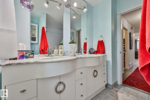 Dual vanity with a stone countertop, individual mirrors, and track lighting - 8932 187 Street Nw, Edmonton, AB - Indoor Photo Showing Bathroom