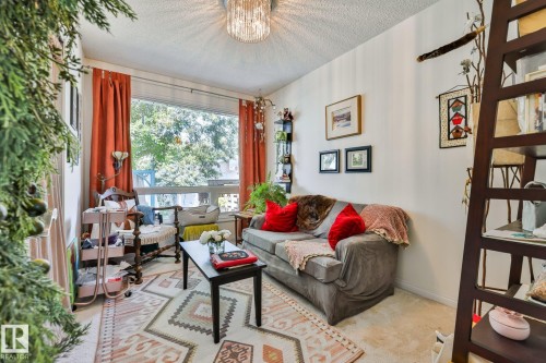 Bright living room bathed in natural light through expansive windows with orange drapery - 8932 187 Street Nw, Edmonton, AB - Indoor Photo Showing Living Room