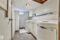 Dedicated laundry area featuring a washer, dryer, built-in cabinetry, and a ceiling-mounted light fixture - 